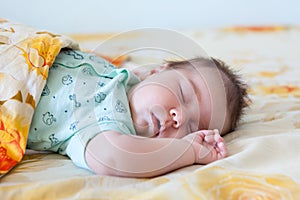 Funny baby sleeping on his back on bed at home. Child daytime, sleeping position