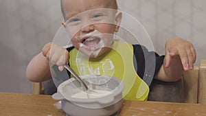 funny baby toddler learning to eat with spoon, child learn eating use teaspoon