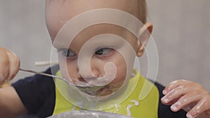 funny baby toddler learning to eat with spoon, child learn eating use teaspoon