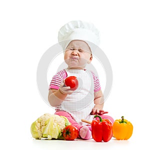 Funny baby weared as cook with vegetables