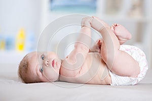 Funny baby weared diaper lying on bed