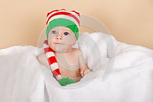 Funny baby is wearing an elf or dwarf hat. Adorable little boy