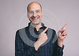 Funny bald man pointing to copy space
