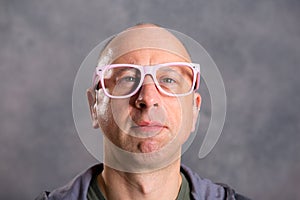 Funny baldheaded man with pink glasses photo