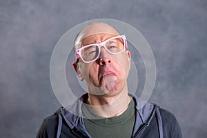 Funny baldheaded man with pink glasses photo