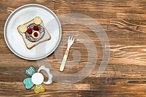 Funny bear face sandwich toast bread with peanut butter, cheese and raspberry on plate wooden background copy space