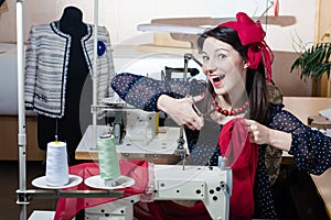 Funny beautiful happy smiling & looking at camera young pinup woman with sewing machine