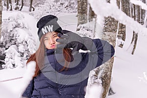 Funny beauty attractive woman with winter fashion clothing is making funny face in snow skii resort woodland photo