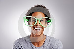 Funny, big glasses and black man with a smile, happy and funky eyewear on a white studio background. Portrait, trendy