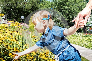 Funny blonde girl in the park. Small pretty female child walking in a summer sunny day