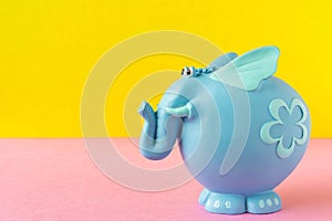 Funny blue toy elephant. On a yellow-pink background