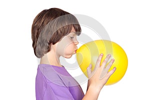 Funny boy blowing up a yellow balloon