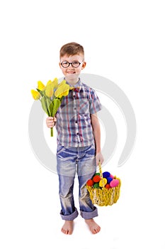 Funny boy with a bouquet of tulips and Easter basket of eggs