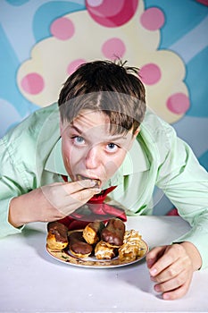 Funny boy eating sweet cakes, hungry and candy man