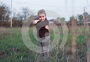 The funny boy grabbed himself with his hands. Portrait in the countryside