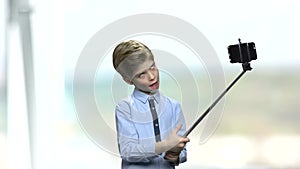 Funny boy grimacing while using monopod.