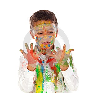 Funny boy with hands and face full of paint