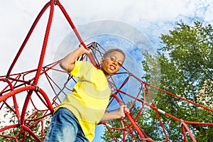 Funny boy holds and stands on red ropes