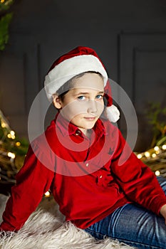 Funny boy in Santa red hat. Happy child having fun on Christmas time