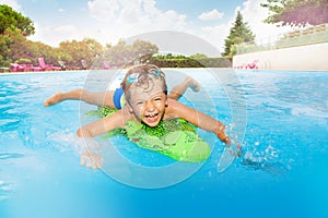 Funny boy swimming with inflatable crocodile