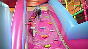 Funny boys playing on inflated slide