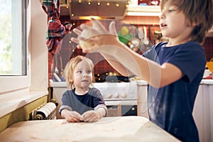 Funny boys are preparing the dough, bake cookies in the kitchen at home