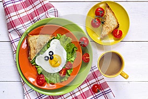 Funny Breakfast with bear-shaped fried egg, toast, cherry tomato