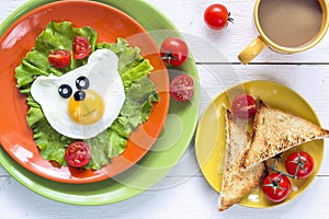 Funny Breakfast with bear-shaped fried egg, toast, cherry tomato