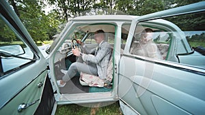 Funny bride and groom in a retro car.