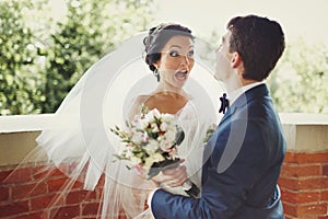 Funny bride looks shocked being hugged by a groom