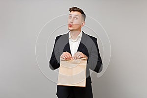 Funny business man holding brown clear empty blank craft paper bag for takeaway mock up isolated on grey background