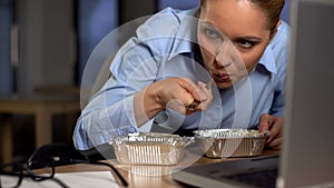 Funny business woman eating stolen food, hiding under computer, lack of money