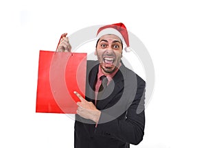 Funny businessman in Christmas Santa hat holding red shopping bag in December and New year sale