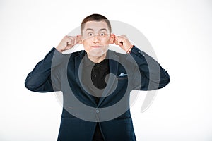 Funny businessman holding his ears