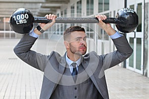 Funny businessman lifting heavy weights