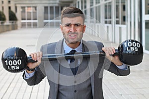 Funny businessman lifting heavy weights