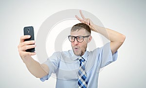 Funny businessman photographing himself on a smartphone. Selfie concept