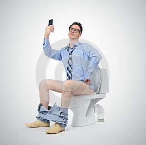 Funny businessman photographing himself in the toilet.