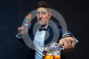 Funny businessman posing with toy guns against gray background