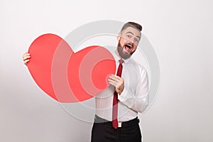 Funny businessman toothy smiling, holding big red heart