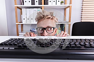 Funny Businessman Hiding Behind Desk