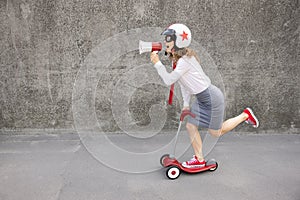 Funny businesswoman riding scooter outdoor