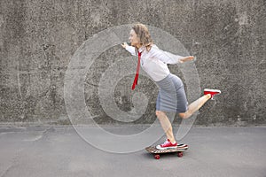 Funny businesswoman riding skateboard outdoor