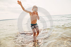 Funny Caucasian boy swimming in lake river with underwater goggles
