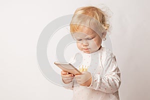 Funny Caucasian little girl feeling angry as she lost game. Mad female child having displeased look because of low battery on cell