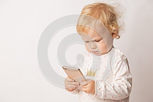 Funny Caucasian little girl feeling angry as she lost game. Mad female child having displeased look because of low battery on cell