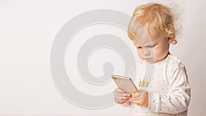 Funny Caucasian little girl feeling angry as she lost game. Mad female child having displeased look because of low battery on cell