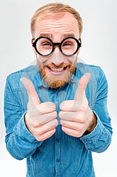 Funny cheerful bearded man in round glasses showing thumbs up