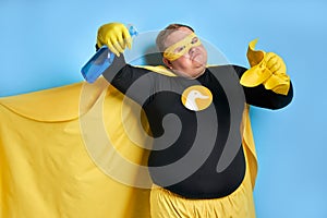 Funny cheerful fat man with detergent in hands
