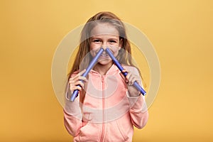 Funny cheerful happy girl having fun, putting her hair-curlers into her nose